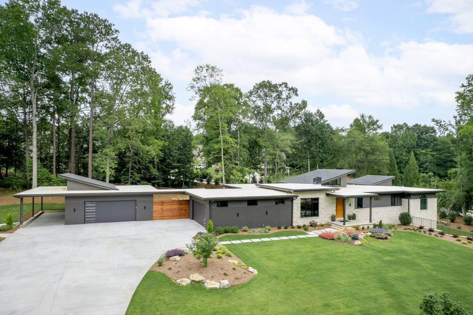 Driveway sweeping to the garage with the house beyond — The Ortiz Home, custom home built by Ironwood Construction Group in Sugar Hill, Georgia