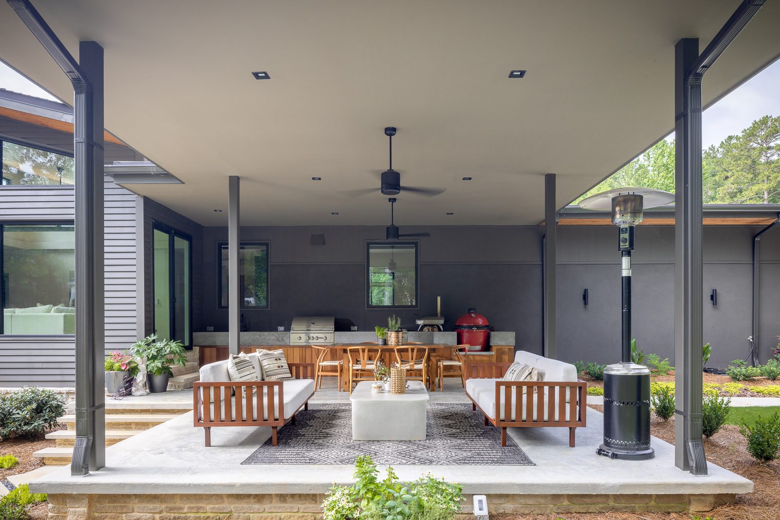 Covered rear patio with lounge seating and patio heaters — The Ortiz Home, custom home built by Ironwood Construction Group in Sugar Hill, Georgia