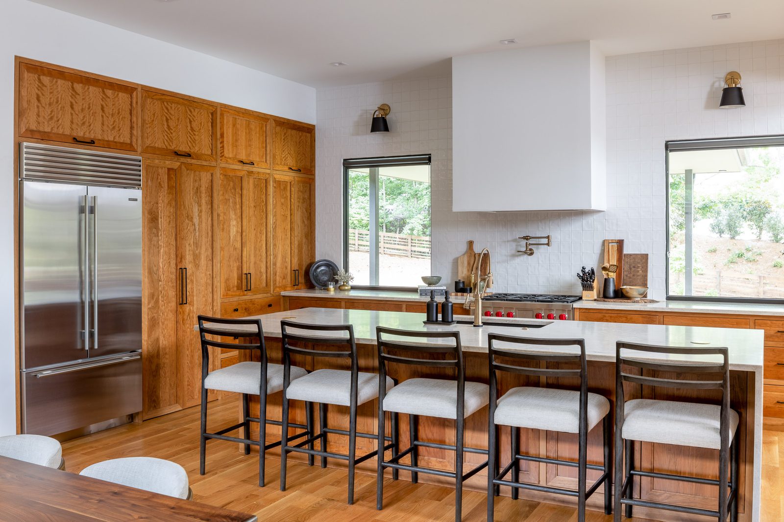 Kitchen island with barstools and integrated refrigeration — The Ortiz Home, custom home built by Ironwood Construction Group in Sugar Hill, Georgia