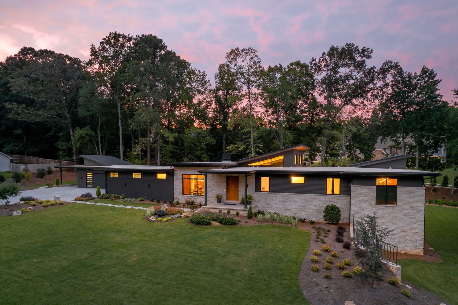 Twilight exterior seen across the lawn — The Ortiz Home, custom home built by Ironwood Construction Group in Sugar Hill, Georgia