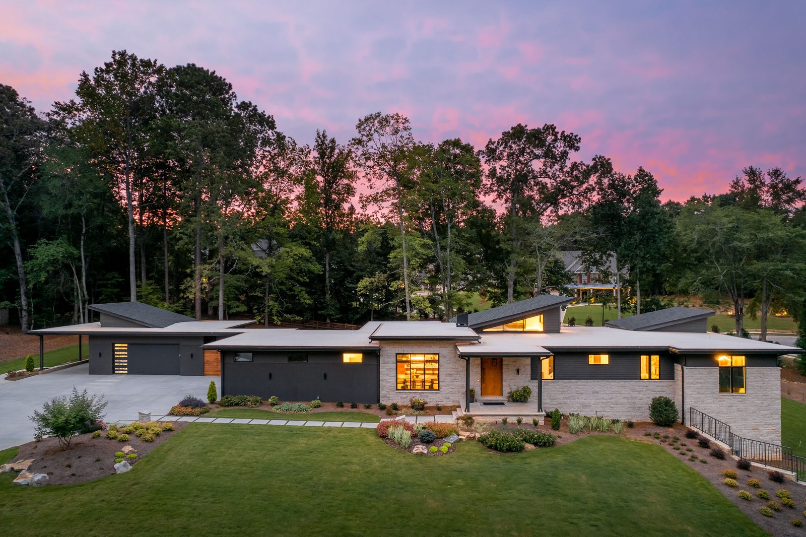 Twilight front elevation with the windows lit — The Ortiz Home, custom home built by Ironwood Construction Group in Sugar Hill, Georgia