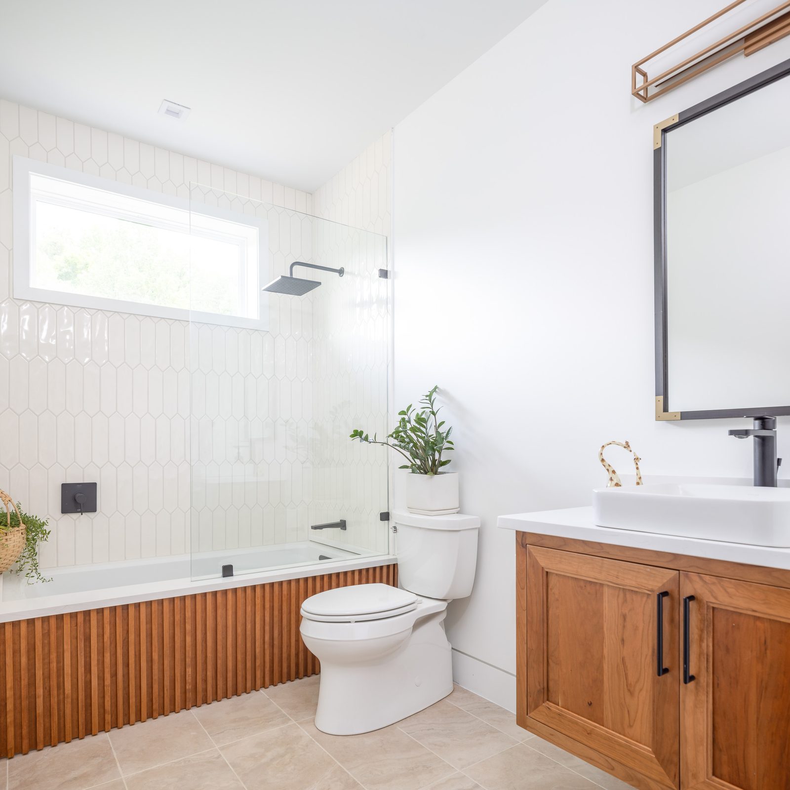Hall bath with soaking tub and walnut vanity — The Ortiz Home, custom home built by Ironwood Construction Group in Sugar Hill, Georgia