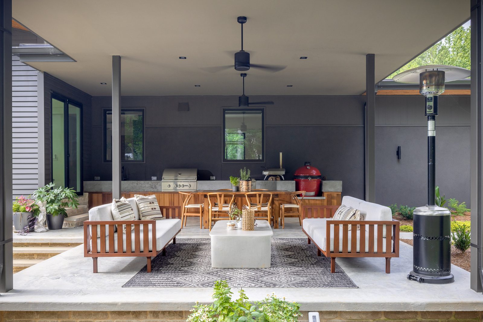 Covered rear patio with outdoor kitchen and lounge seating — The Ortiz Home, custom home built by Ironwood Construction Group in Sugar Hill, Georgia