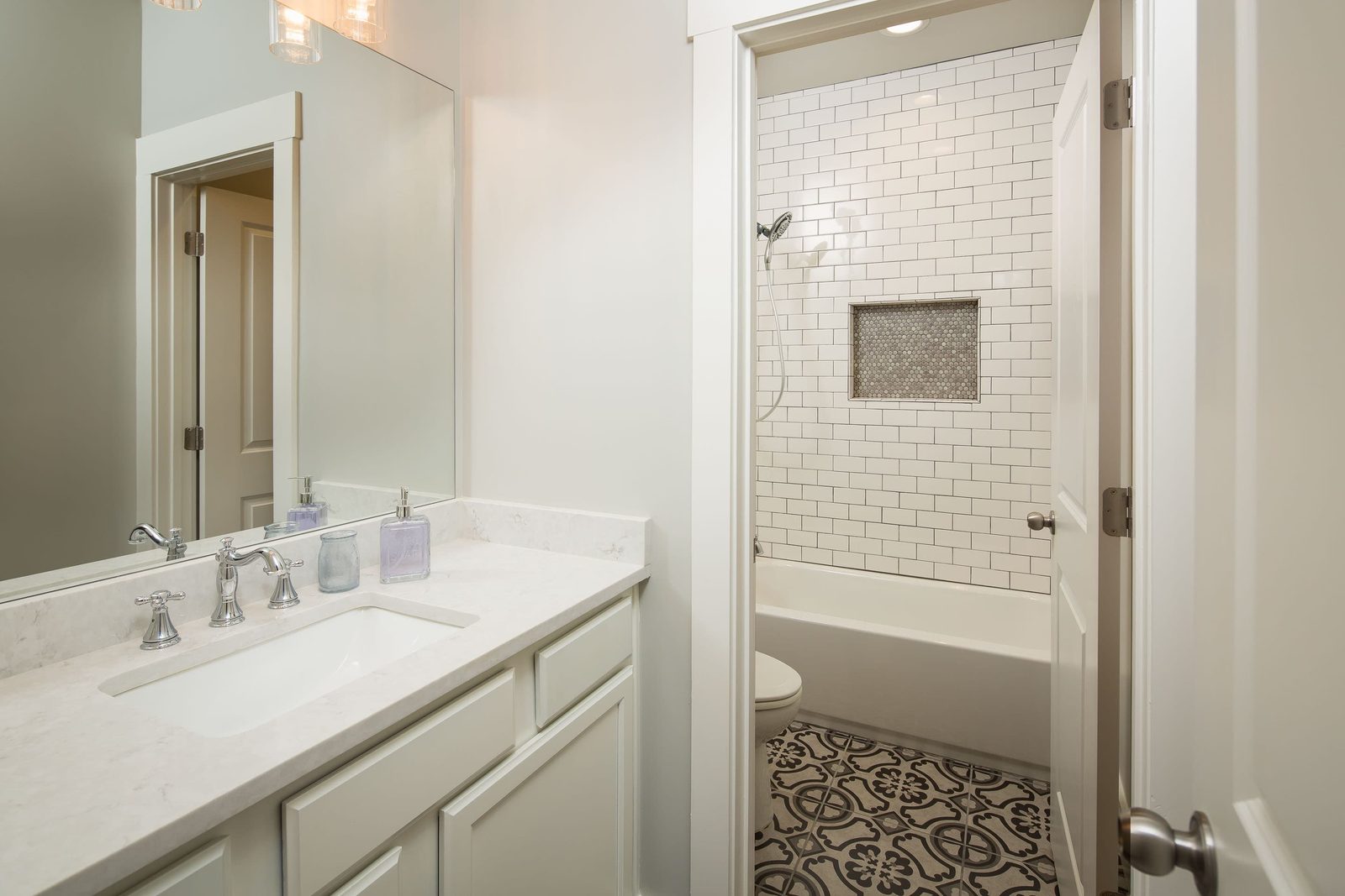 Secondary bath with vanity and tiled tub surround — Austin Garner Rd, custom home built by Ironwood Construction Group