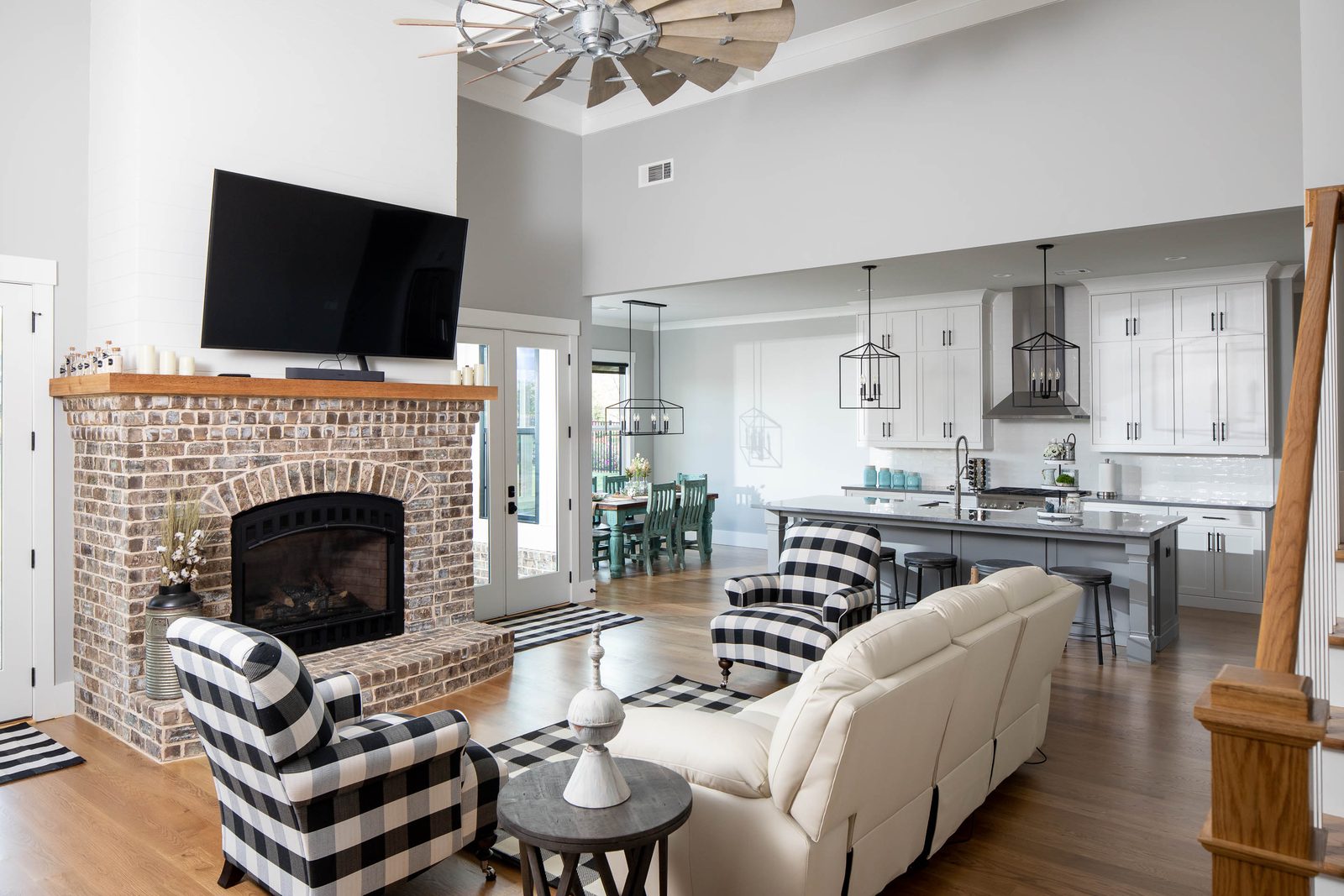 Great room with buffalo-check chairs beside the brick fireplace — Glausier, custom home built by Ironwood Construction Group