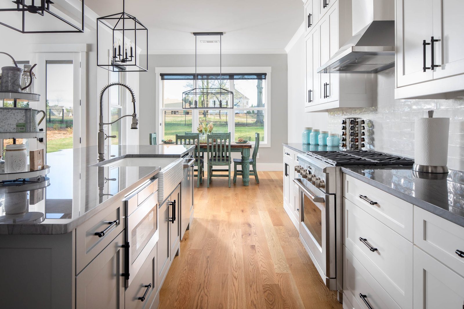 Kitchen with brass faucet and range, open to the breakfast area — Glausier, custom home built by Ironwood Construction Group