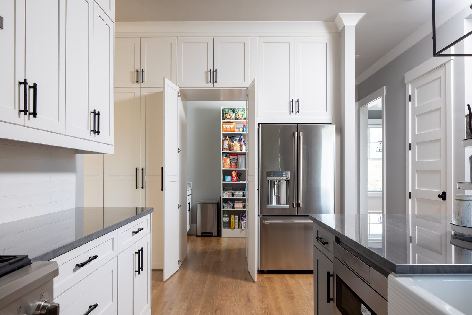 Butler's pantry doorway beside the refrigerator — Glausier, custom home built by Ironwood Construction Group
