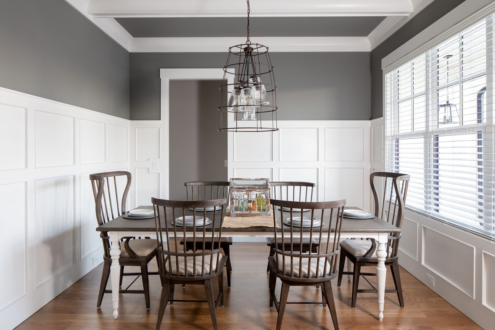 Dining room with board-and-batten wainscoting and lantern chandelier — Glausier, custom home built by Ironwood Construction Group