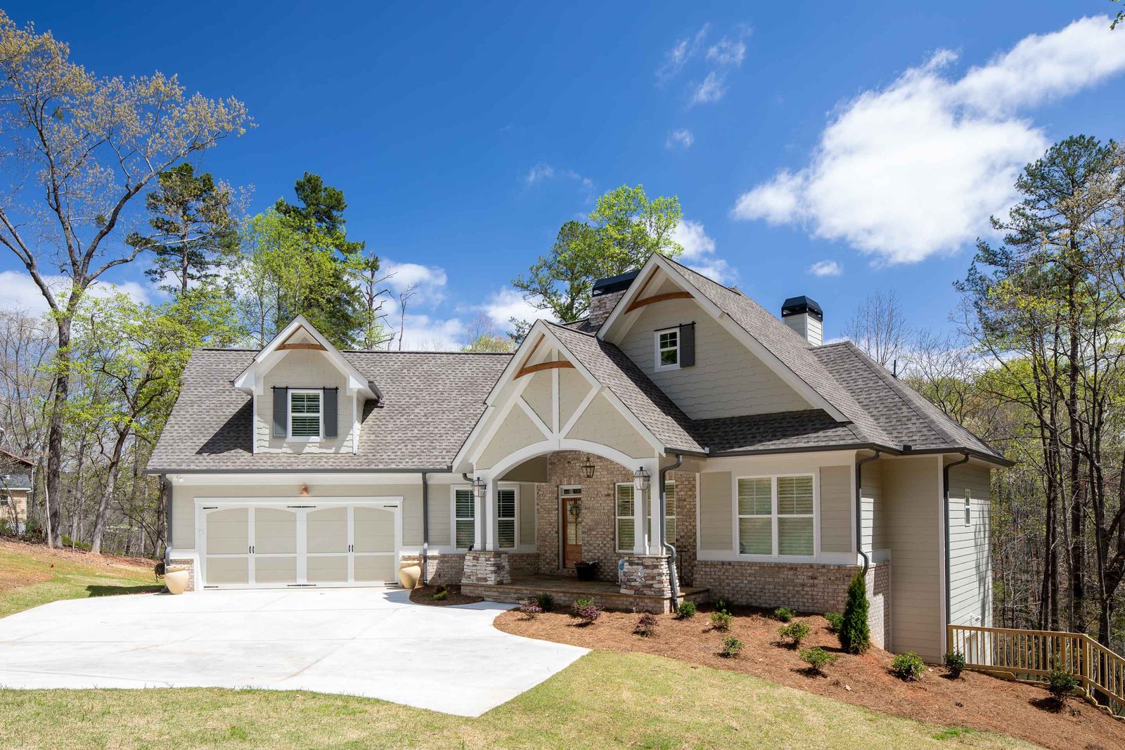 Craftsman elevation with three-car garage and stone accents — Glausier, custom home built by Ironwood Construction Group