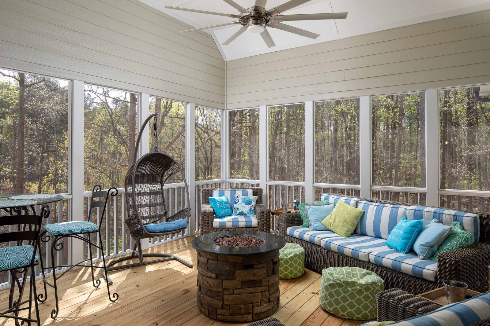 Screened porch with fire table and wicker seating — Imbriale, custom home built by Ironwood Construction Group