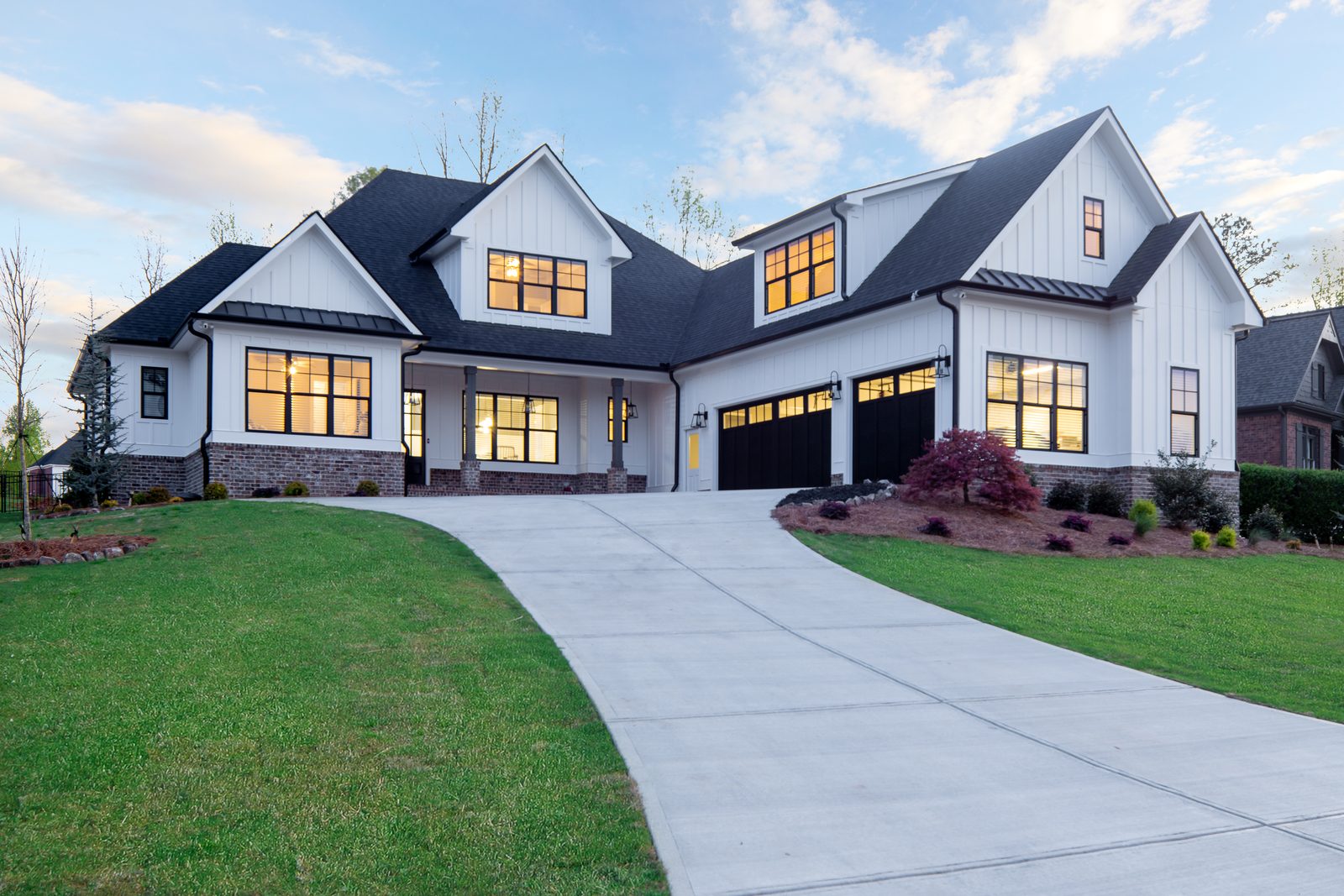 Front elevation of the white board-and-batten farmhouse with three-car garage — Spring 2020 Custom Home, custom home built by Ironwood Construction Group