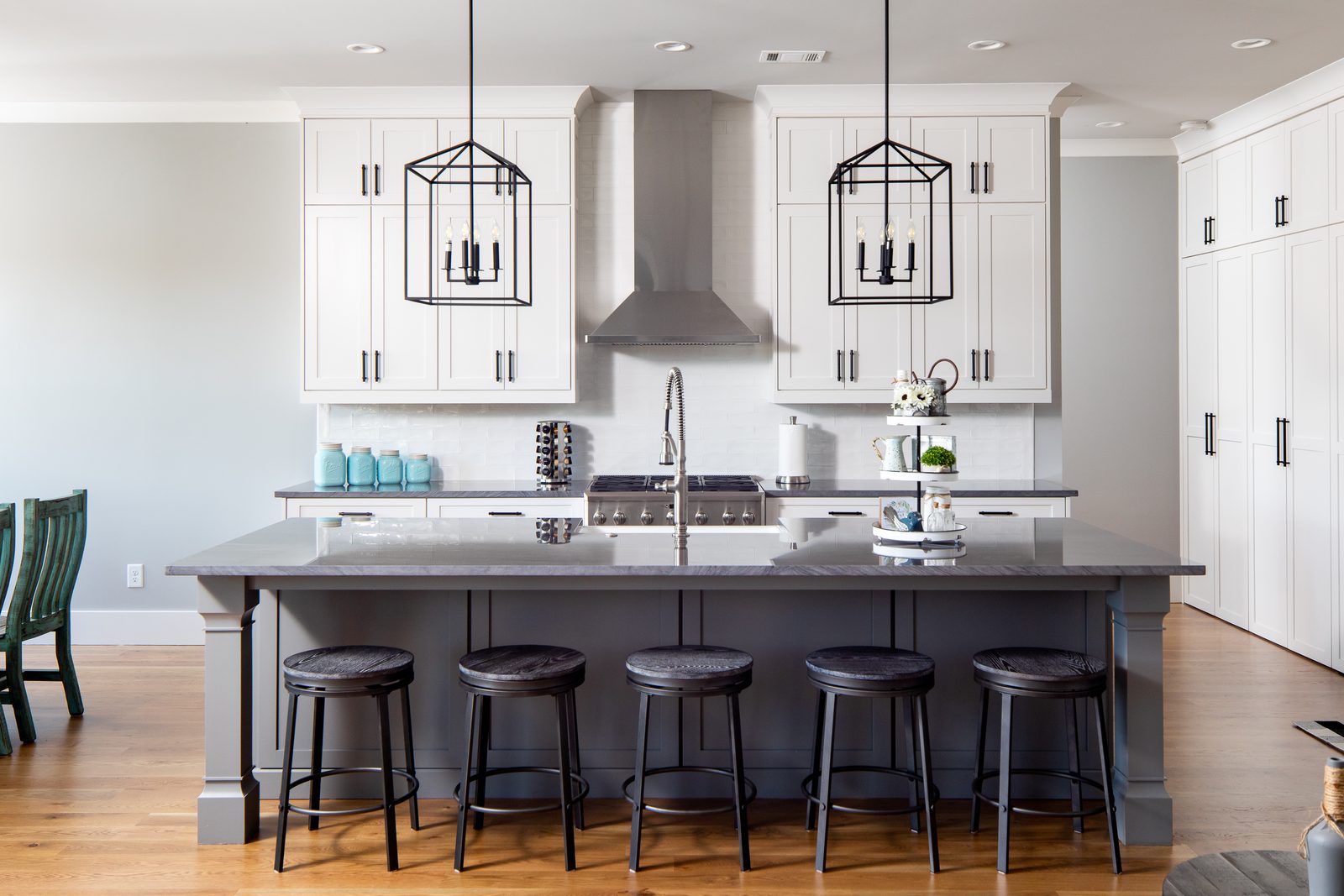 Kitchen with grey island, white cabinetry and stainless hood — Spring 2020 Custom Home, custom home built by Ironwood Construction Group