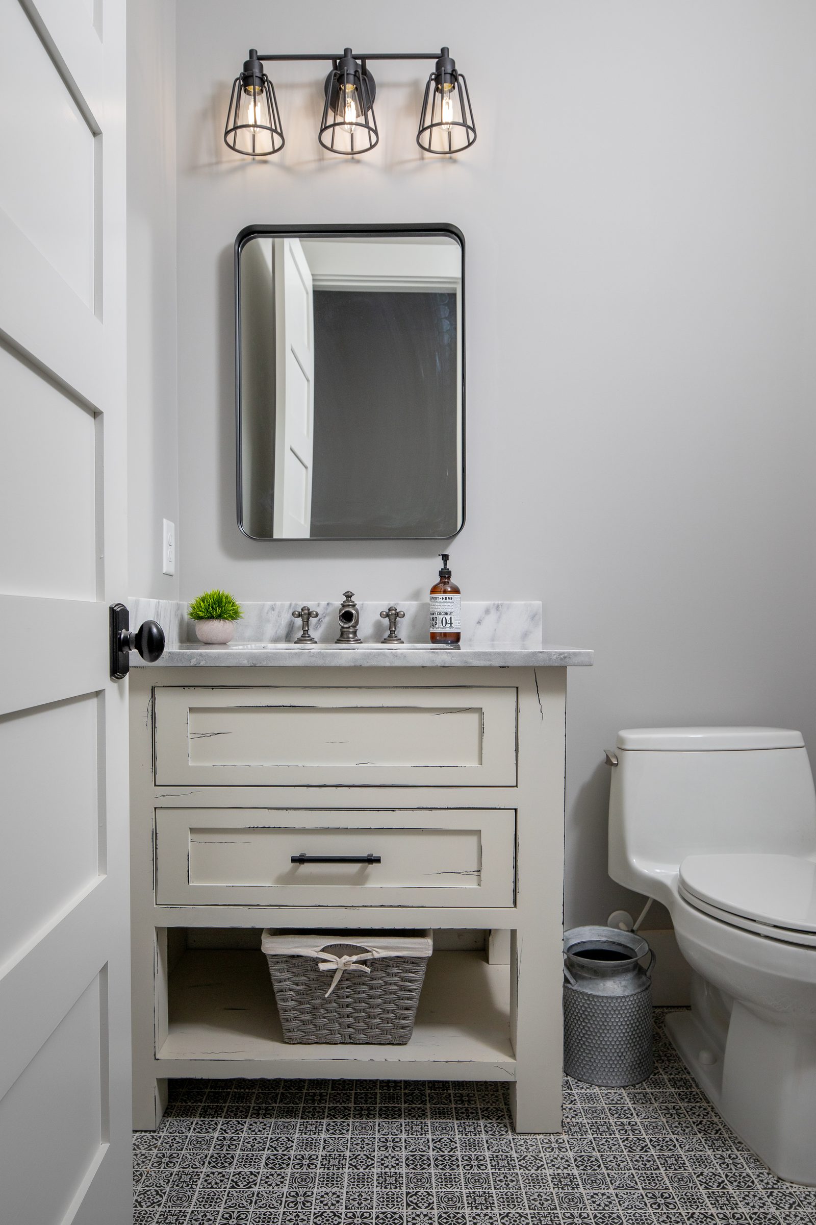 Powder room with vanity and patterned tile floor — Spring 2020 Custom Home, custom home built by Ironwood Construction Group