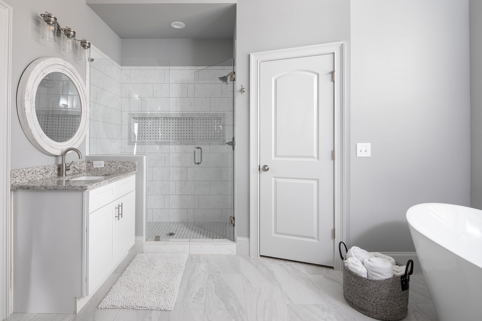 Primary bath with tiled walk-in shower and freestanding tub — Spring 2020 Custom Home, custom home built by Ironwood Construction Group