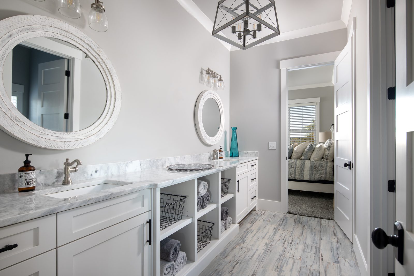 Hall bath vanity with round mirrors and open shelving — Spring 2020 Custom Home, custom home built by Ironwood Construction Group