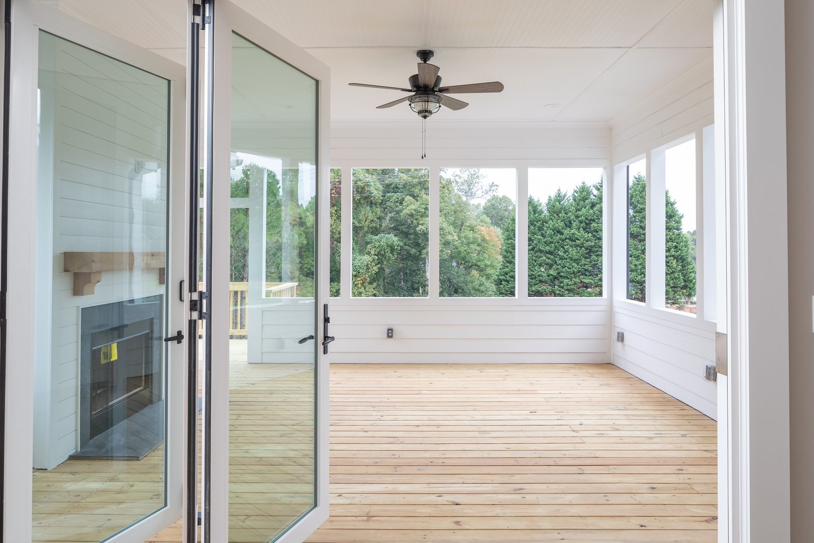 Screened porch with vaulted shiplap ceiling and folding glass doors — Shadburn Ferry, custom home built by Ironwood Construction Group in Buford, Georgia