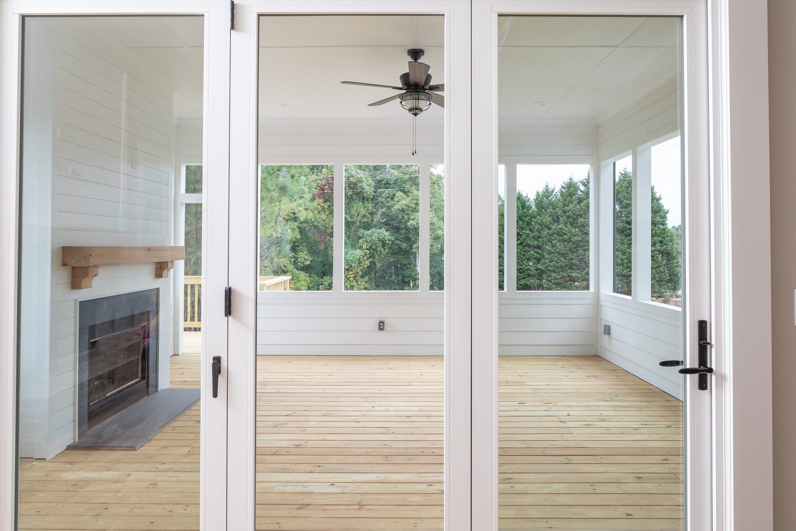 Screened porch with fireplace and ceiling fan — Shadburn Ferry, custom home built by Ironwood Construction Group in Buford, Georgia