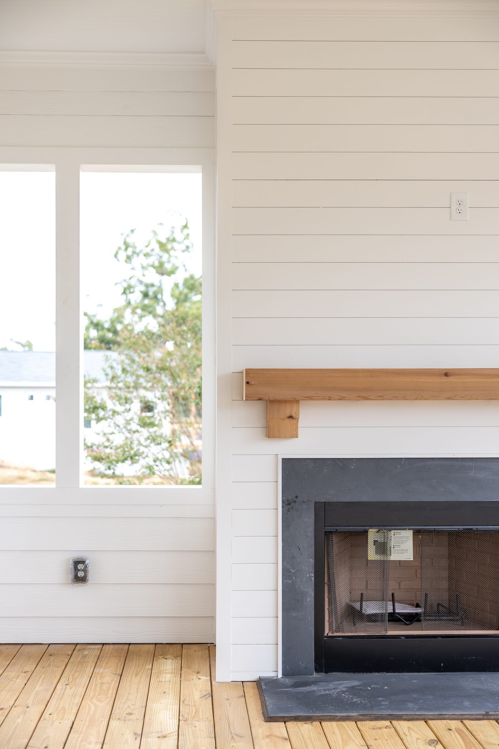 Screened-porch fireplace with rough-sawn wood mantel — Shadburn Ferry, custom home built by Ironwood Construction Group in Buford, Georgia