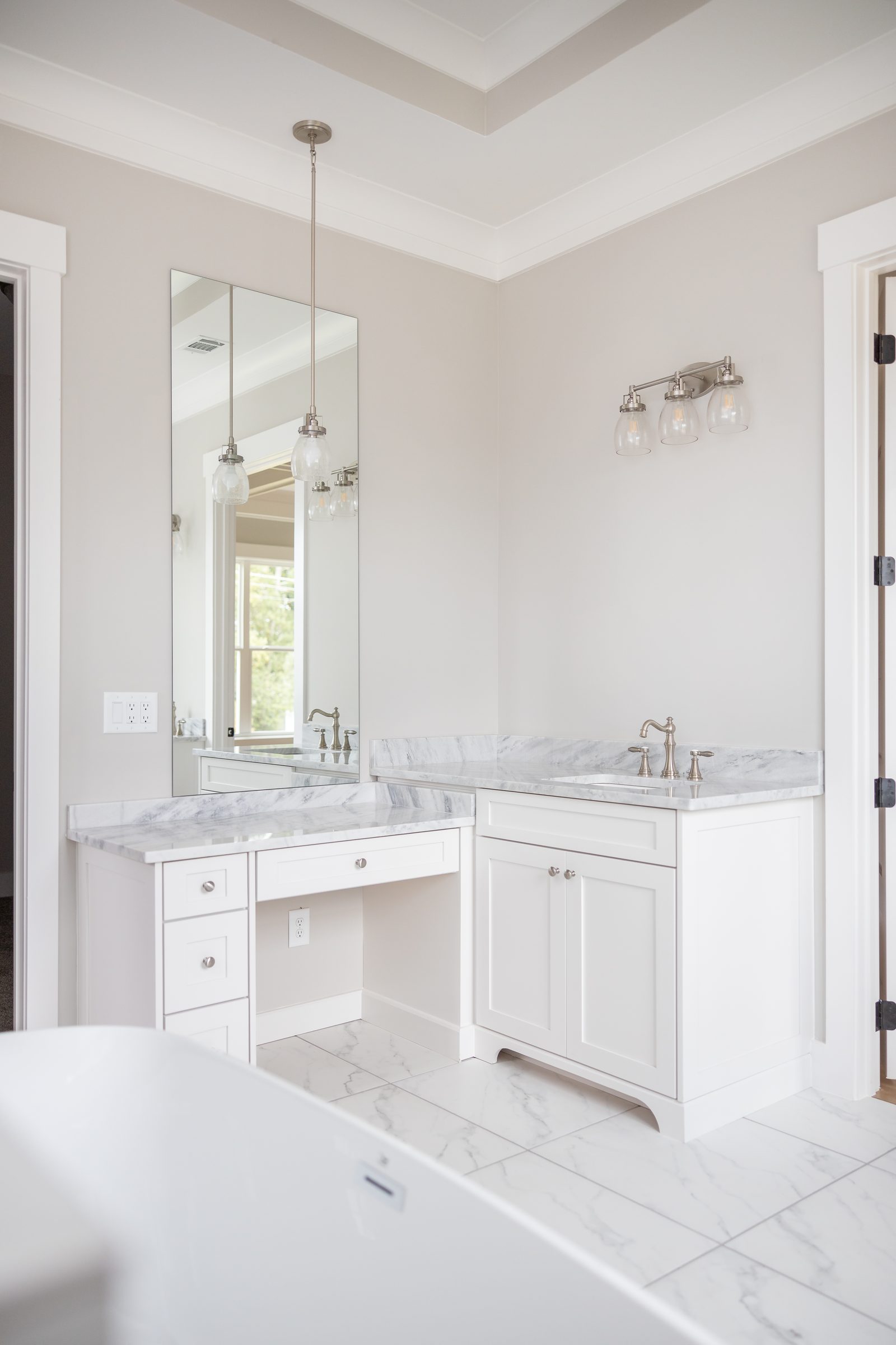 Primary bath twin vanities beyond the freestanding tub — Shadburn Ferry, custom home built by Ironwood Construction Group in Buford, Georgia