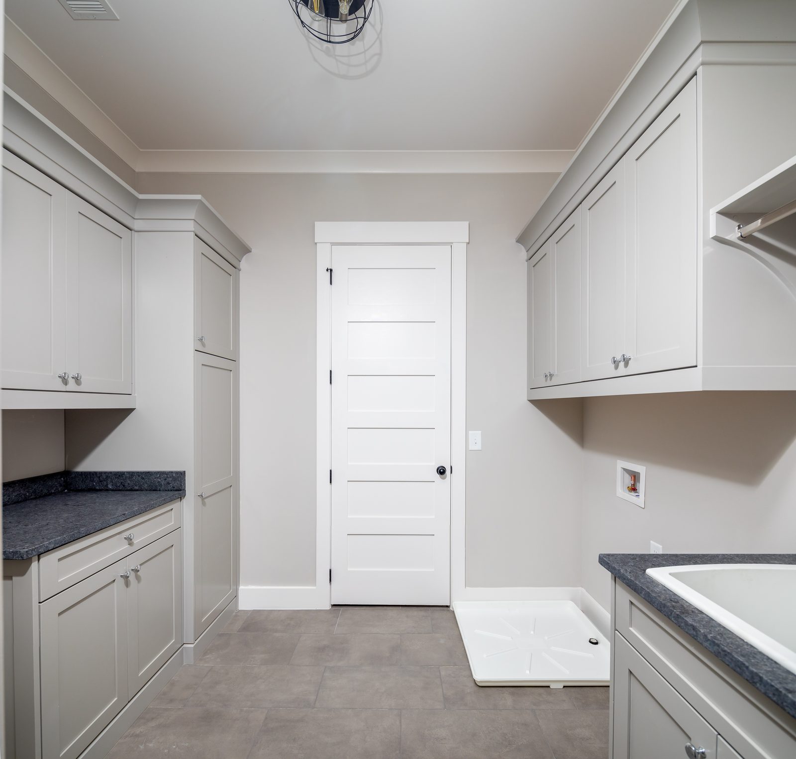 Laundry room with cabinetry, folding counter and utility sink — Shadburn Ferry, custom home built by Ironwood Construction Group in Buford, Georgia