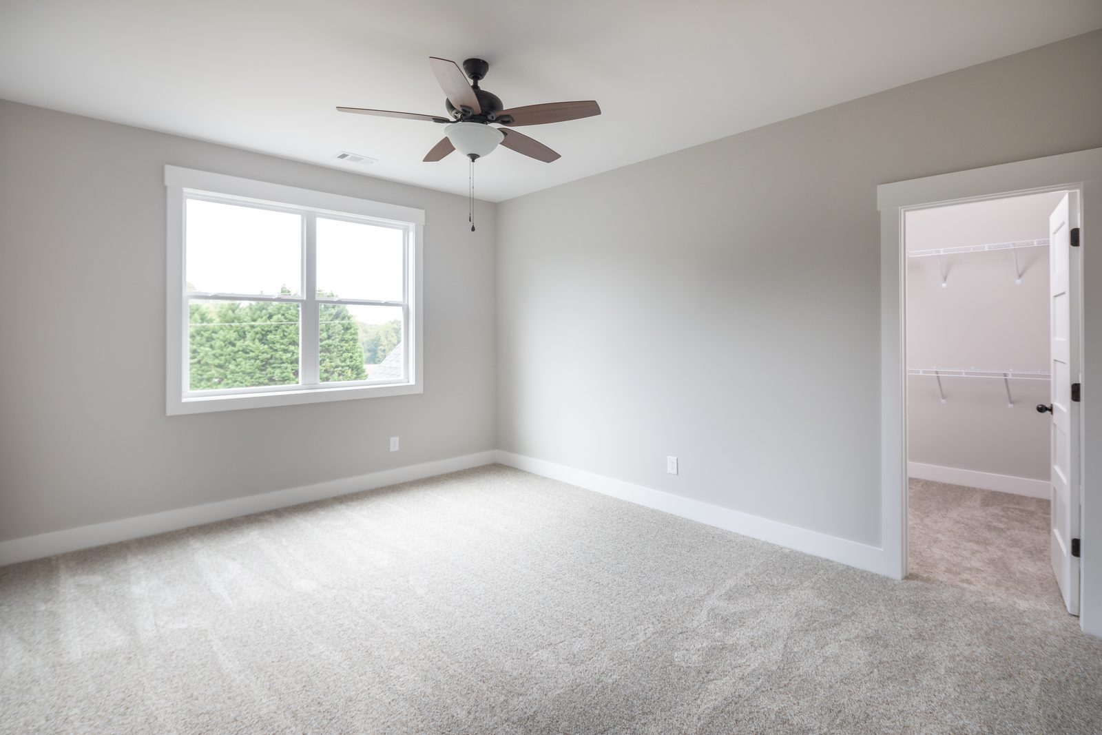 Secondary bedroom with ceiling fan and closet door — Shadburn Ferry, custom home built by Ironwood Construction Group in Buford, Georgia