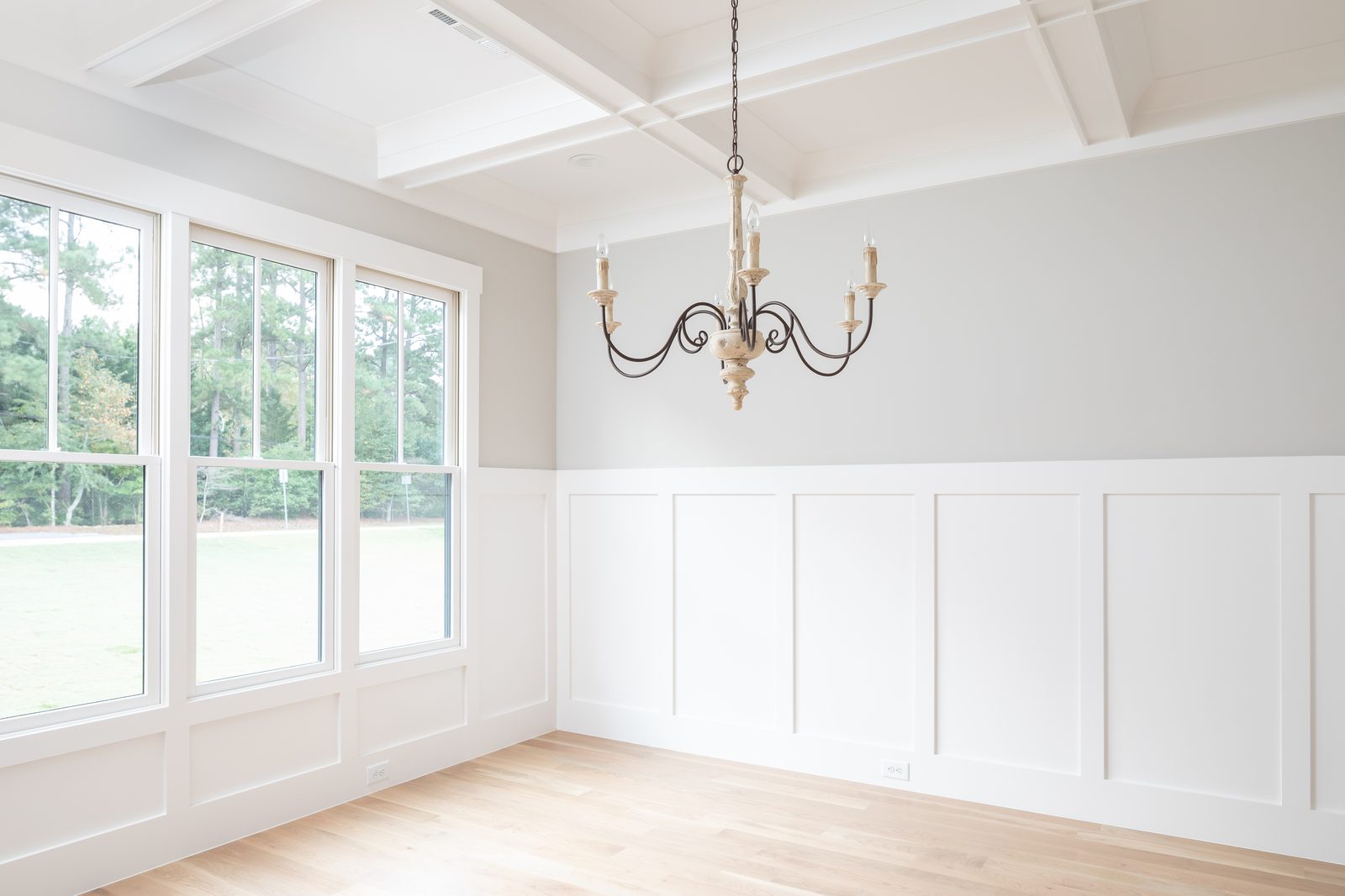 Dining room with a wall of windows and a coffered ceiling — Shadburn Ferry, custom home built by Ironwood Construction Group in Buford, Georgia